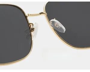 Gros plan des plaquettes de nez en silicone souple sur lunettes de soleil en métal doré