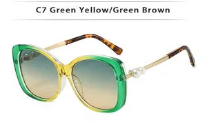 Detail of C7 fashion sunglasses featuring pearl accents and yellow-green gradient frame