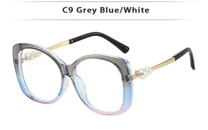 Detail of gradient grey blue sunglasses frame with gold metal temples and pearl accents
