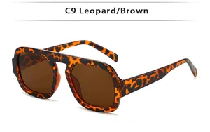 Détail de lunettes de soleil carrées en écaille avec verres marrons et monture léopard