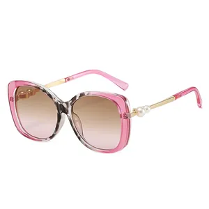 Pink oversized sunglasses with pearl decorated gold metal temples and gradient lenses