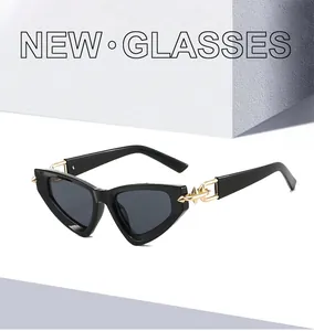 Close-up of cat-eye sunglasses featuring golden metal arrow design on black frame