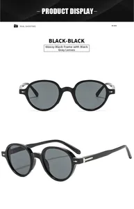 Detail view of bright black round sunglasses with sleek grey lenses and silver studs