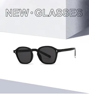 Detail of round black sunglasses with dark gray lenses and silver metal accents