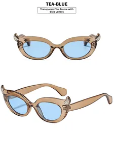Detail of cat eye sunglasses with devil horn accents in tea-blue transparent frames