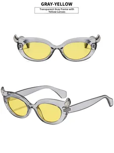 Detail view of cat eye sunglasses with transparent grey frames and yellow lenses