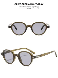 Detail view of olive green round sunglasses with metal arrow accents and grey lenses