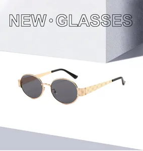 Détail de lunettes de soleil en métal doré avec motifs gravés sur les branches