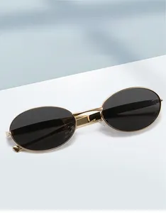 Detailed view of oval vintage sunglasses with a gold metal frame and dark black lenses