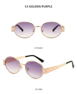 Détail de lunettes de soleil ovales dorées avec gravures de roses sur les branches et verres violets