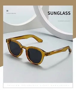 Macro detail of retro oval sunglasses featuring metal rivets and brown transparent frames