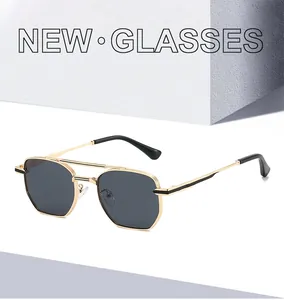 Close-up of double-bridge gold metal aviator sunglasses with dark grey lenses
