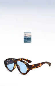 Dettaglio di occhiali da sole tartarugati con lenti blu per un look retrò alla moda