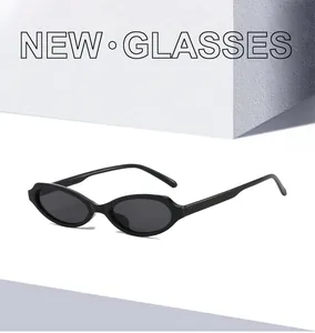 Side view of trendy black oval cat-eye sunglasses with dark lenses on a minimalist background