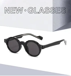 Detailed view of black round retro sunglasses with unique wavy textured frame edges