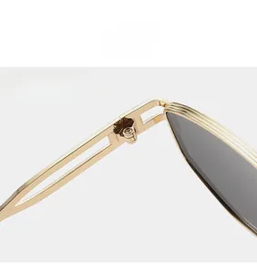 Detail view of sturdy hinges and hollow temple design on gold metal frame sunglasses