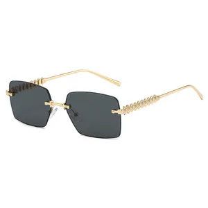 Goldene randlose quadratische Sonnenbrille mit dunklen Gläsern und Reliefmuster-Bügeln