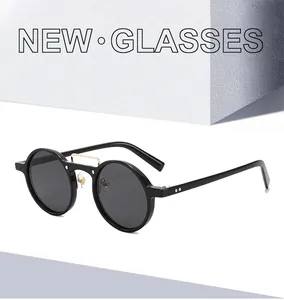 Detail of vintage round sunglasses with black frames and gold metal bridge on modern props
