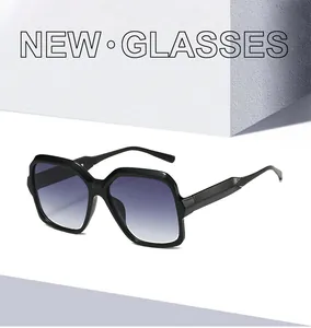 Detail view of square black sunglasses with gradient lenses on a minimalist stone background
