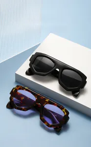 Détails de lunettes de soleil géométriques noires et écaillées sur des socles blancs