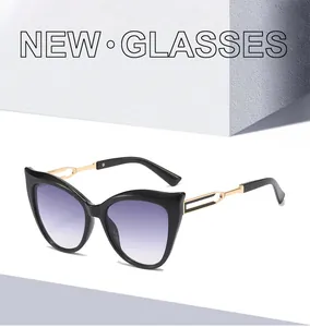 Détail de lunettes œil-de-chat avec branches en métal doré et verres dégradés violets