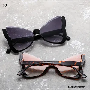 Detail shot of butterfly sunglasses in black and tortoise frames on stone surface