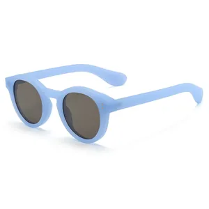 Fashionable round light blue matte sunglasses with grey lenses and metal rivets