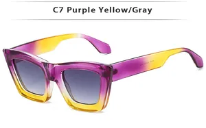 Detailed shot of cat-eye sunglasses with purple and yellow gradient frames and gray lenses