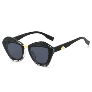 Lunettes de soleil papillon tendance avec texture noire et détails en métal doré