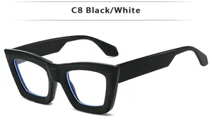 Detail view of retro thick black frame sunglasses with subtle cat-eye style and light blue lenses