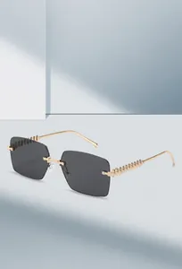 Detalle de gafas de sol cuadradas al aire con patillas de cadena dorada y remaches punk