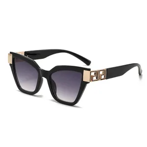 Lunettes de soleil œil de chat noires avec charnières dorées et verres dégradés