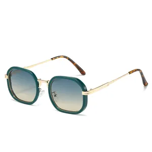 Lunettes de soleil polygonales avec monture vert foncé et branches dorées sur fond blanc