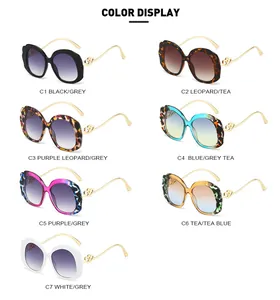 Detailed color display of oval sunglasses with wavy frames and double heart metal hinges