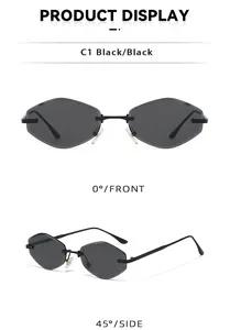 Close-up of black rimless square sunglasses with geometric cut edges and gold metal bridge