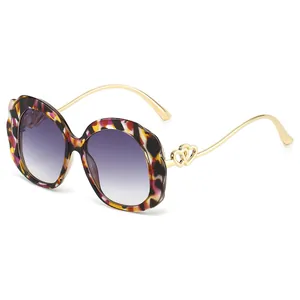 Fashionable oversized oval sunglasses with tortoiseshell frame and double-heart metal detail