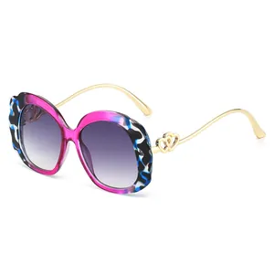 Oval fashion sunglasses with marble pattern frames and gold metal heart detail