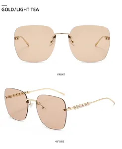 Détail de lunettes de soleil sans monture dorées avec verres thé clair et perles élégantes
