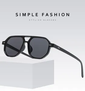 Detail of black pilot sunglasses with silver dot accents on a modern double-bridge frame