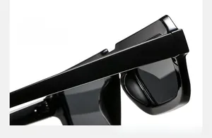 Détail de lunettes de soleil carrées noir brillant montrant la charnière robuste et fini