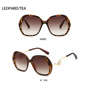 Detailed view of leopard print sunglasses with gold metal temples and pearl accents