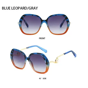 Detail of blue leopard sunglasses featuring metal temples with pearl accents and gradient lenses