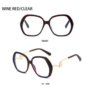 Macro detail of wine red oversized sunglasses with gold temples and pearl accents