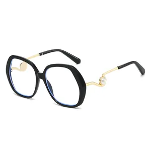 Oversized retro sunglasses with black frames and gold wavy temples featuring pearl detail