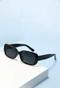 Detail of black thick frame sunglasses with glossy finish on a modern display stand
