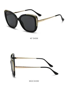 Detail view of large sunglasses featuring gold textured scales and metal temples