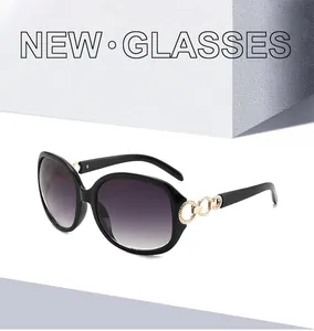 Détail de lunettes de soleil ovales noires avec élégantes branches en chaîne dorée