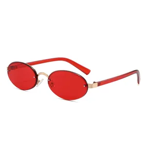 Vintage rimless oval sunglasses with red lenses and gold metal accents on white background