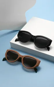 Close-up of black and khaki cat eye sunglasses with metal hinge detail and sleek frames