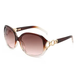 Lunettes de soleil oversize pour femme avec verres dégradés marron et détail de chaîne dorée